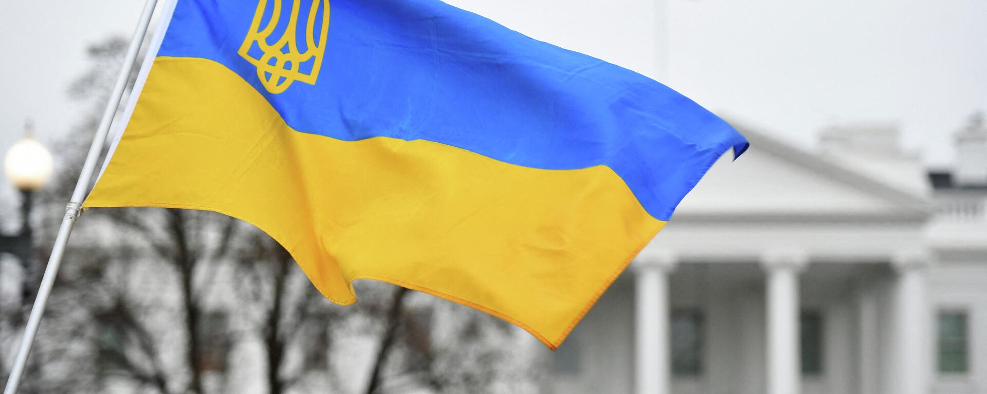 Флаг Украины с гербом развевается, когда активисты собираются на площади Лафайет в знак протеста против российского вторжения в Украину в Вашингтоне - Sputnik Абхазия, 1920, 15.06.2022