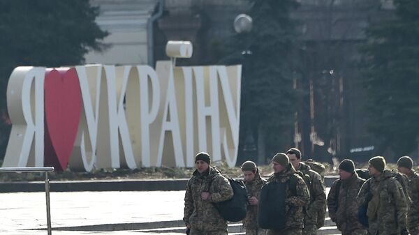 Украинские военные проходят мимо таблички с надписью Я люблю Украину, установленной на площади Независимости в столице Украины Киеве - Sputnik Абхазия