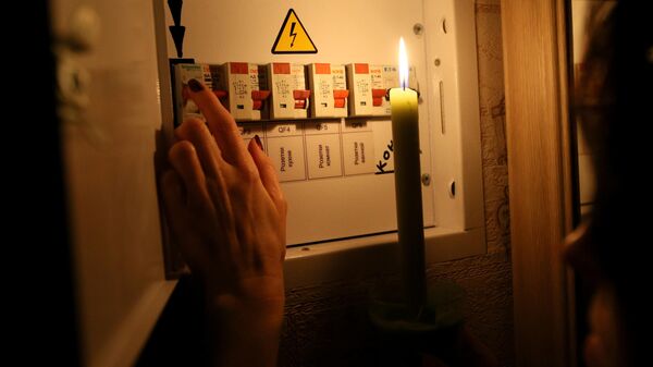 Девушка у электрического щитка в своей квартире во время тестового отключения электричества  - Sputnik Аҧсны