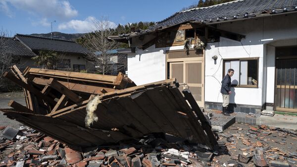 Суши-мейкер Акио Ханзава перед своим поврежденным землетрясением рестораном в Сироиси, префектура Мияги - Sputnik Абхазия