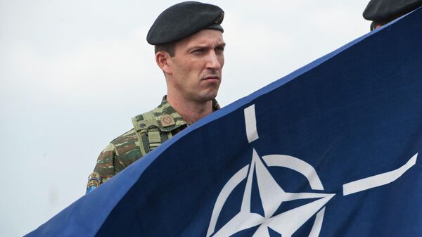 Члены миротворческих сил под руководством НАТО в Косово (KFOR) держат флаг НАТО - Sputnik Абхазия