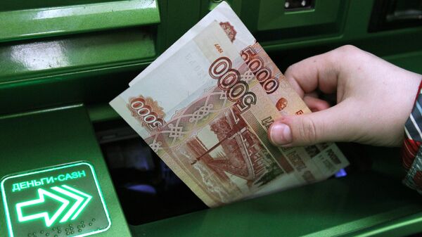 Клиент Сбербанка вносит наличные деньги в банкомат - Sputnik Аҧсны