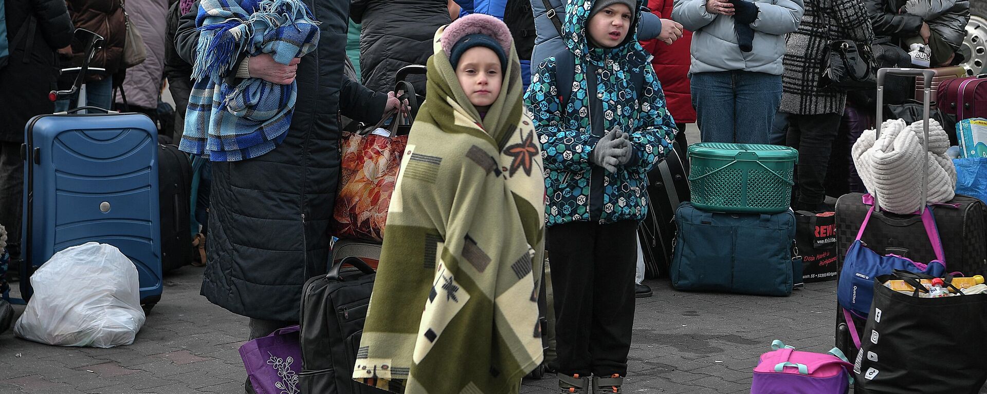 Люди стоят со своим багажом в ожидании посадки в автобусы, которые доставят их дальше в Польшу или за границу из временного приюта для беженцев - Sputnik Абхазия, 1920, 04.05.2022