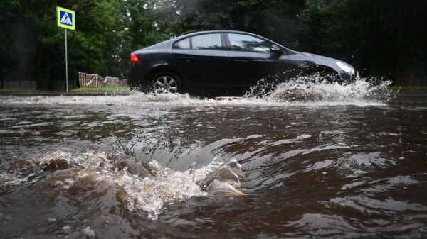 Автомобиль едет по подтопленной из-за дождя дороге в Москве - Sputnik Аҧсны