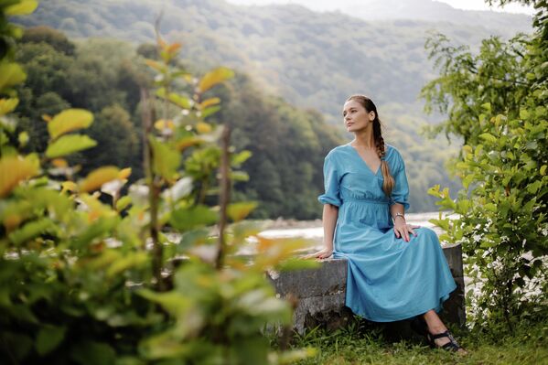 Во время поездки в село Каман, туристка присела отдохнуть недалеко от реки Гумиста и полюбоваться чистой горной рекой. - Sputnik Абхазия