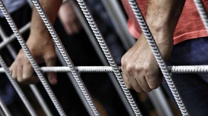 Руки подсудимого за решеткой