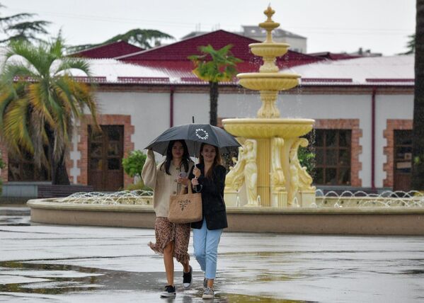 Веселые девушки решили прогуляться под осенним дождем по сухумской набережной. - Sputnik Абхазия