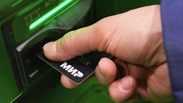Пользователь использует банковскую карту Мир в банкомате Сбербанка в Красноярске - Sputnik Абхазия