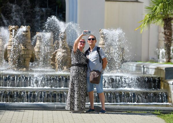 Туристы фотографируются на фоне одной из главных визиток Абхазии - фонтана с грифонами у драмтеатра в Сухуме. - Sputnik Абхазия