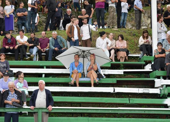Любители конно-спортивных игр удобно расположились на трибуне и увлеченно наблюдали, несмотря на небольшой дождь. - Sputnik Абхазия