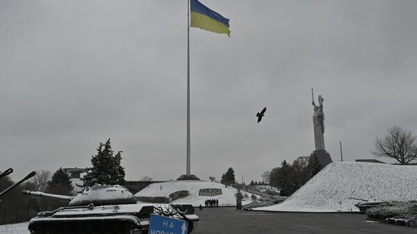 Люди идут рядом с монументом Родина-мать в музее под открытым небом Второй мировой войны в Киеве во время первого снегопада - Sputnik Абхазия