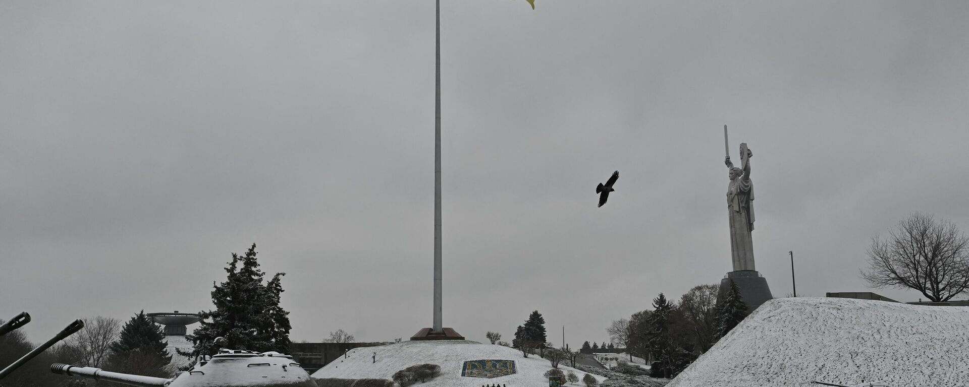 Люди идут рядом с монументом Родина-мать в музее под открытым небом Второй мировой войны в Киеве во время первого снегопада - Sputnik Абхазия, 1920, 17.11.2022