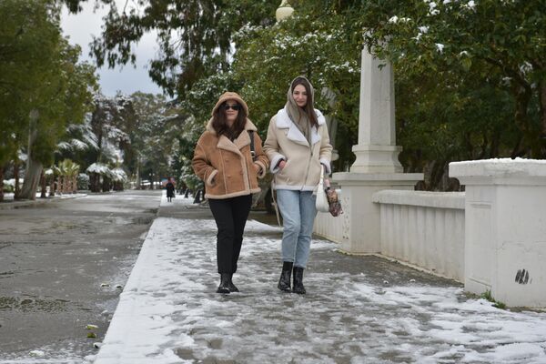 Для кого-то снегопад - не помеха прогулкам по набережной. - Sputnik Абхазия