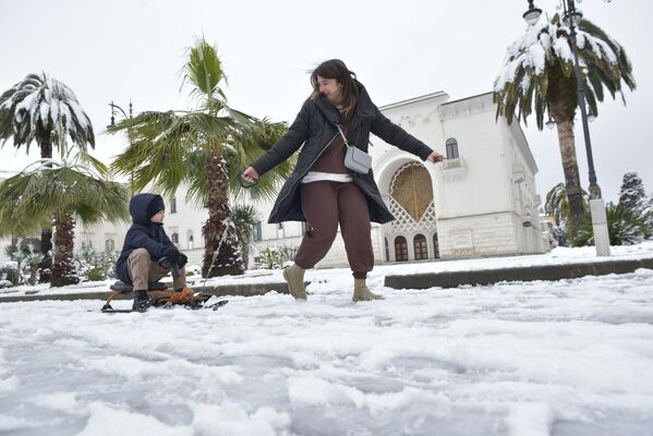 В феврале жителей Абхазии порадовал снег на побережье, который  стал поводом для семейных прогулок по набережной Сухума. - Sputnik Абхазия