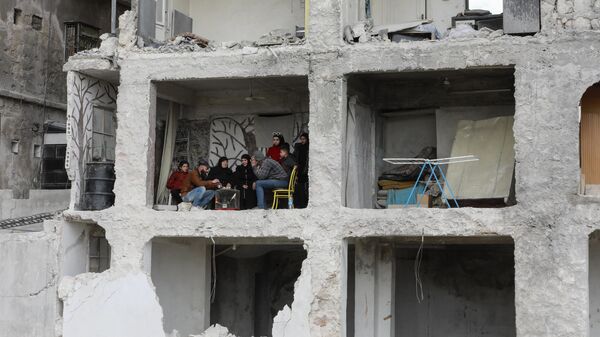 Семья за столом в здании, пострадавшем в результате землетрясения силой 7,8 балла, в районе Аль-Машарка города Алеппо, Сирия - Sputnik Абхазия