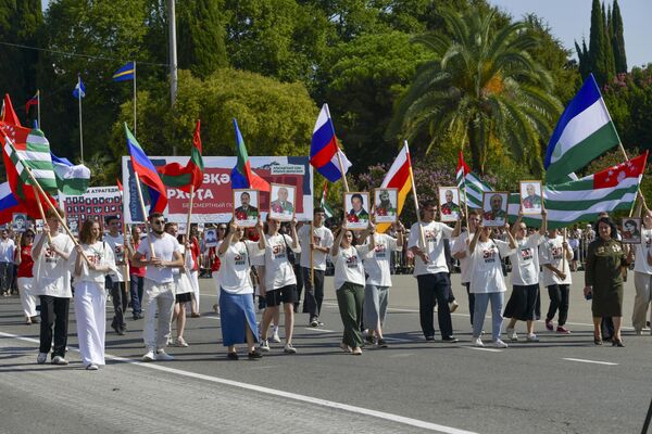 Молодежь Абхазии прошла по площади Свободы с государственными флагами Абхазии и стран, с которыми у нее заключен договор о признании суверенитетов. - Sputnik Абхазия
