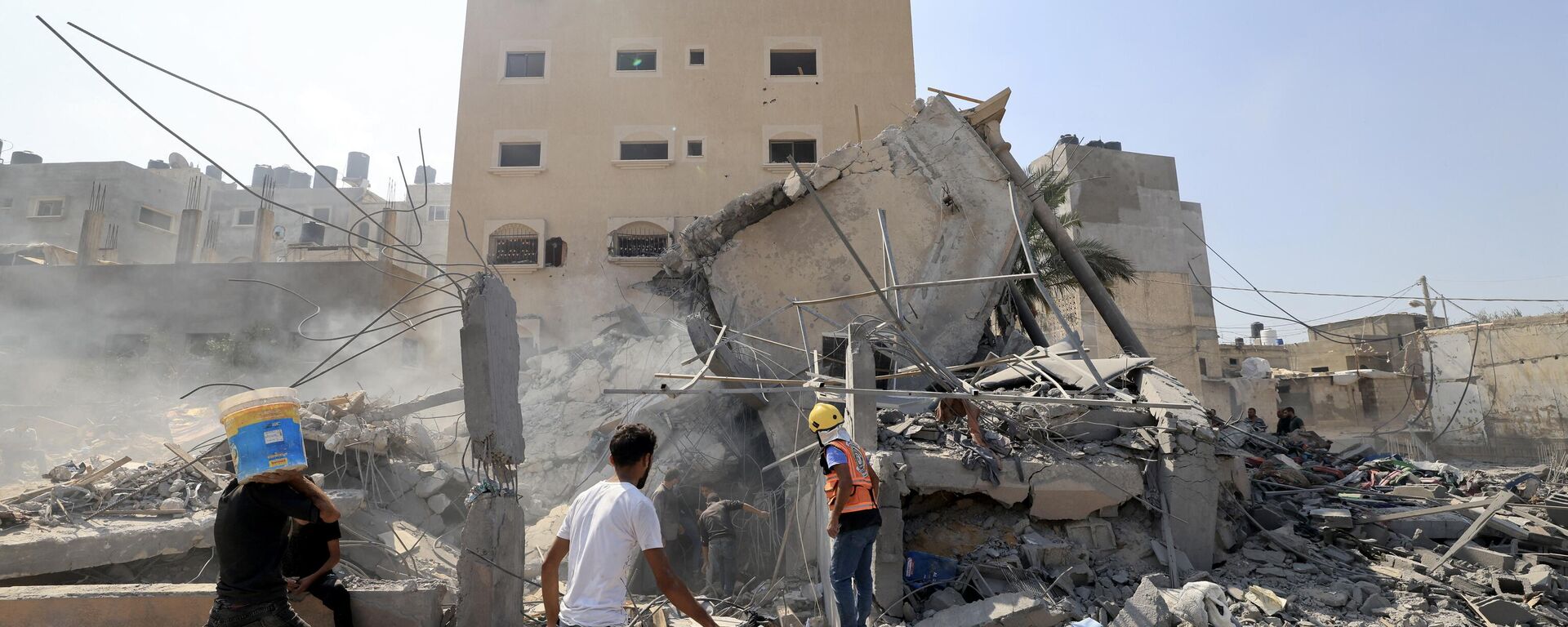 Палестинцы осматривают обломки рухнувшего здания после израильского удара в Хан-Юнисе на юге сектора Газа, 14 октября 2023 года - Sputnik Абхазия, 1920, 20.10.2023