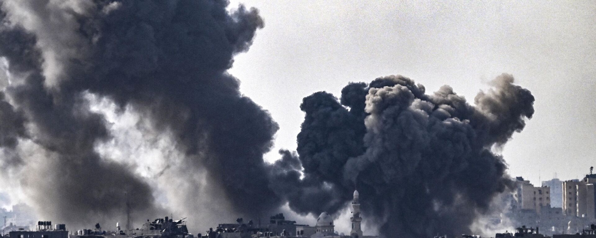 На снимке, сделанном в Сдероте, видны шлейфы дыма, поднимающиеся над зданиями во время израильского удара по северной части сектора Газа 14 октября 2023 года - Sputnik Абхазия, 1920, 19.10.2023