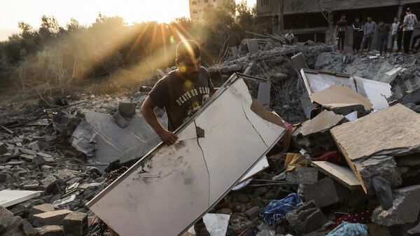 Мужчина осматривает ущерб, нанесенный его дому после израильских ударов по лагерю Рафах на юге сектора Газа - Sputnik Аҧсны