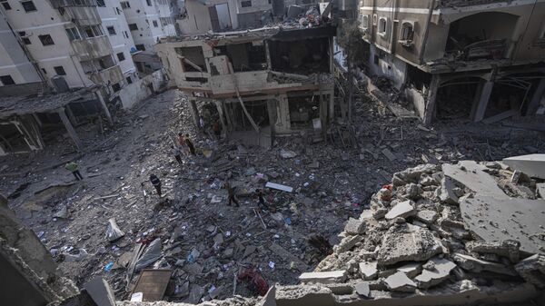 Палестинцы проходят среди разрушений в результате израильской бомбардировки в городе Газа - Sputnik Аҧсны