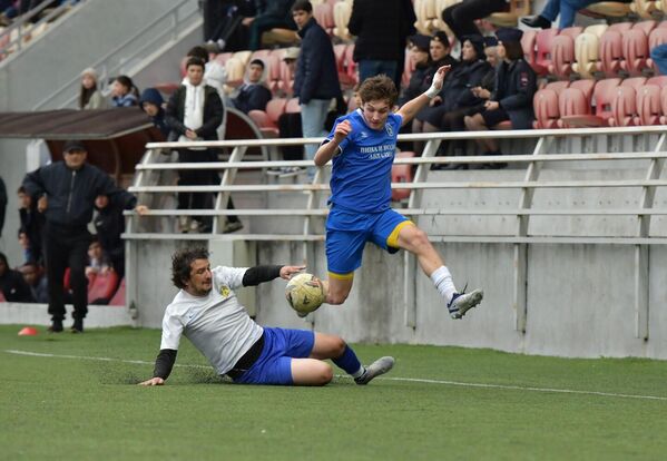 Футболист &quot;Афона&quot; пытается в подкате выбить мяч у соперника. - Sputnik Абхазия