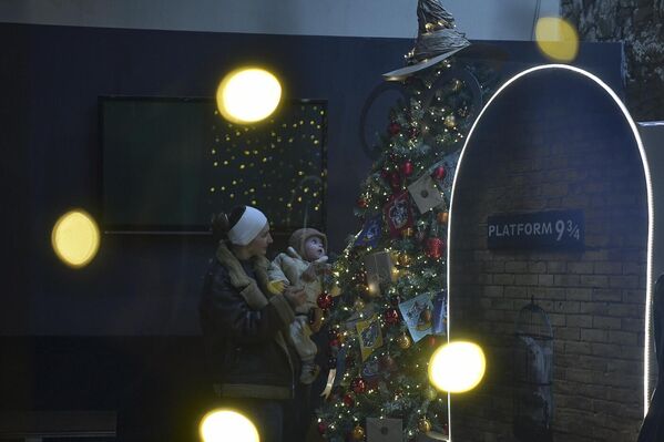 Яркая и нарядная елка привлекла внимание любознательного ребенка. - Sputnik Абхазия