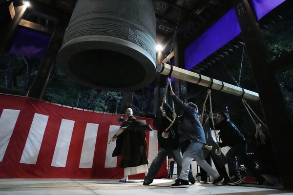 Люди бьют в гигантский колокол, чтобы отпраздновать Новый год в буддийском храме Зоджодзи, через несколько минут после полуночи в Токио, Япония. - Sputnik Абхазия