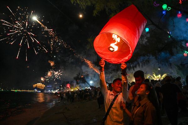 Пара выпускает фонарь во время празднования Нового года на пляже в Сиануквиле, Камбоджа. - Sputnik Абхазия