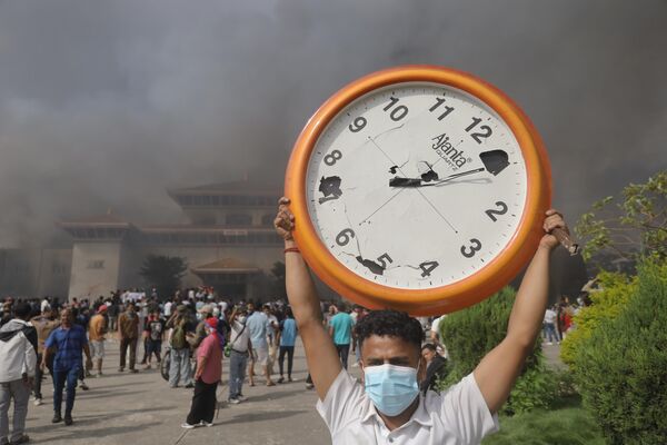 Непальский протестующий позирует с часами, снятыми со стены Федерального парламента в Катманду.  - Sputnik Абхазия