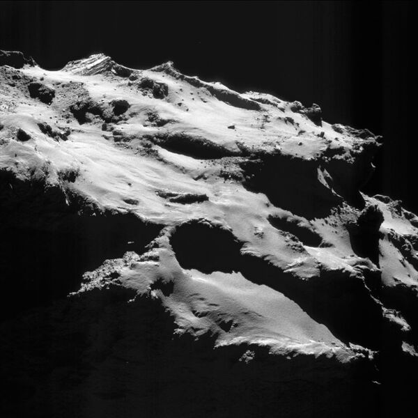 Усиленное одиночное изображение с камеры NavCam, сделанное 18 сентября 2016 года, когда зонд Розетта находился на расстоянии 12,1 км от центра ядра кометы 67P/Чурюмова-Герасименко. Масштаб изображения около 1,0 м на пиксель, размер кадра примерно 1,1 км в поперечнике. - Sputnik Абхазия