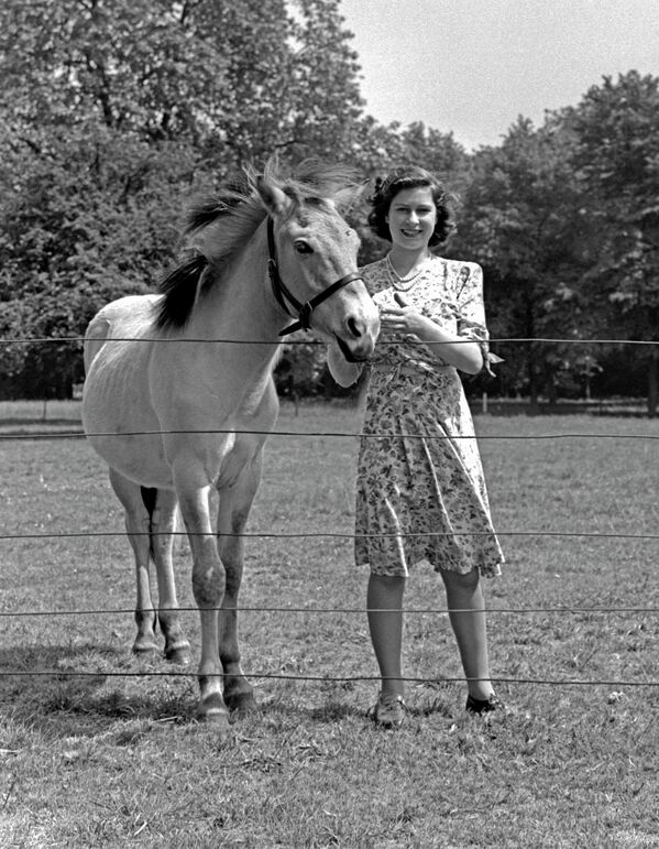 Принцесса Элизабет (королева Елизавета II) рядом с лошадью в саду Виндзорского замка - Sputnik Абхазия