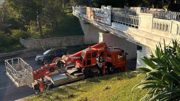 Подъемная машина не смогла проехать под эстакадой в Сухуме и зацепила ее - Sputnik Абхазия