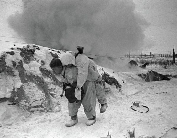 Советский санитар выносит с поля боя раненого бойца во время боя под Ленинградом. - Sputnik Абхазия