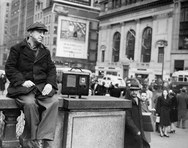 Портовый рабочий Отто Файнберг слушает новости перед Нью-Йоркской библиотекой - Sputnik Абхазия