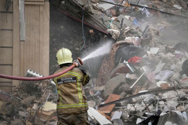 Пожарный тушит тлеющие обломки - Sputnik Абхазия