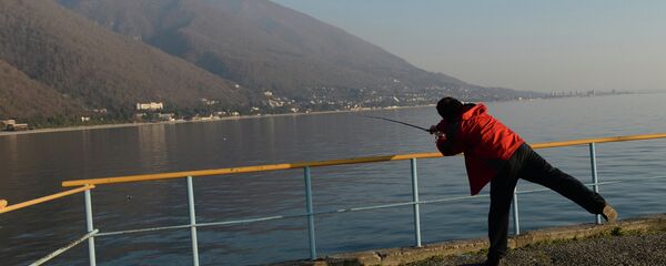 Рыбак ловит рыбу с пирса в Гаграх. Архивно6е фото. Рыбак ловит рыбу с пирса в Гаграх. Архивно6е фото. - Sputnik Абхазия