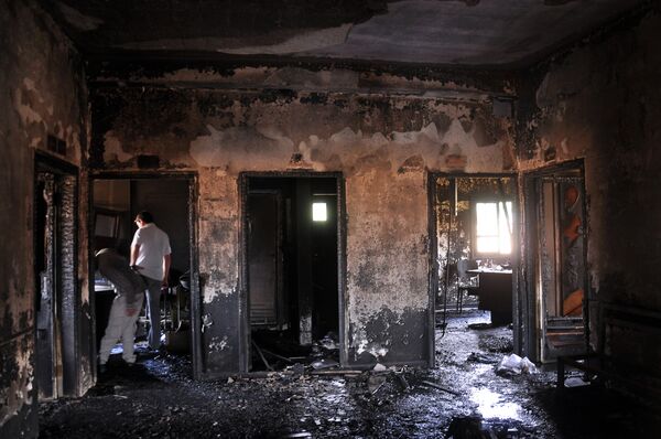 Люди осматривают повреждения в клинике Эль-Камышлы после пожара. 31 марта 2015. - Sputnik Абхазия