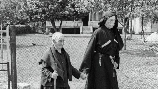 Женщина-долгожитель Хьфаф Ласурия, прожившая 137 лет, гуляет со своим сыном. - Sputnik Аҧсны