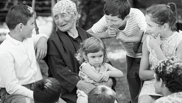 Женщина-долгожитель Хьфаф Ласурия (137 лет) из села Кутол в окружении правнуков. - Sputnik Аҧсны