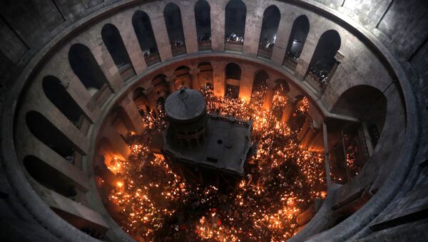 Христиане держат свечи, зажженные от Благодатного огня в храме Гроба Господня в Старом городе Иерусалима. Архивное фото. - Sputnik Абхазия