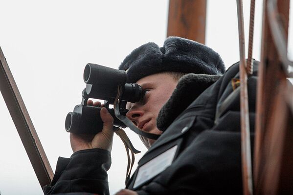 Сотрудник милиции наблюдает в бинокль за обстановкой в зоне. - Sputnik Абхазия