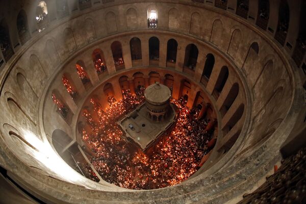 Православные христиане  держат свечи, зажженные от Благодатного огня в храме Гроба Господня в Старом городе Иерусалима. - Sputnik Абхазия