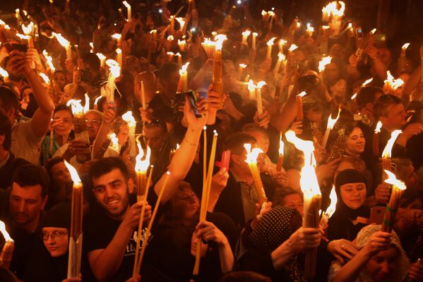 Православные христиане держат свечи, зажженные от Благодатного огня в храме Гроба Господня в Старом городе Иерусалима. - Sputnik Абхазия