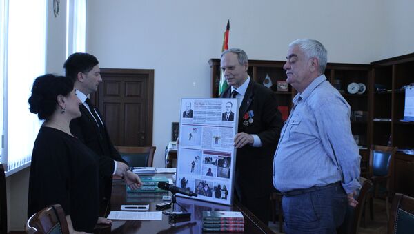 Представитель КПРФ Александр Трубицын передает коллаж из фотографий о водружении флага Абхазии на Северном полюсе - Sputnik Абхазия