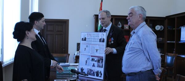 Представитель КПРФ Александр Трубицын передает коллаж из фотографий о водружении флага Абхазии на Северном полюсе Представитель КПРФ Александр Трубицын передает коллаж из фотографий о водружении флага Абхазии на Северном полюсе - Sputnik Абхазия