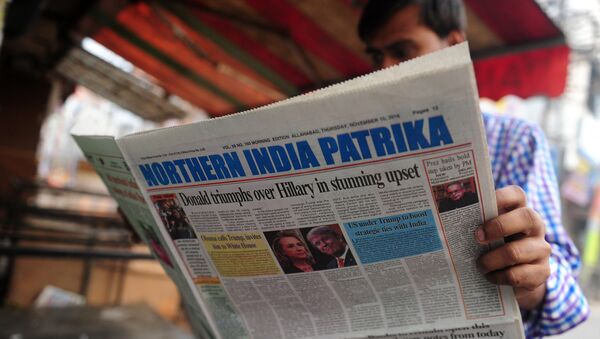 Индийский мужчина читает новости в газете об избрании президента США Дональда Трампа, на улице в Аллахабаде 10 ноября 2016 года - Sputnik Абхазия