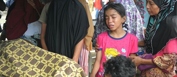 Семья оплакивает своего родственника, который умер после мощного землетрясения в Индонезии - Sputnik Абхазия