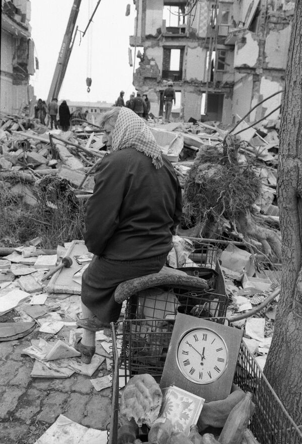 Жительница Спитака на руинах своего дома, разрушенного во время землетрясения. - Sputnik Абхазия