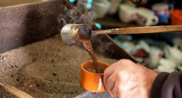 Кофе, сваренный в турке на песке, наливают в чашку - Sputnik Абхазия