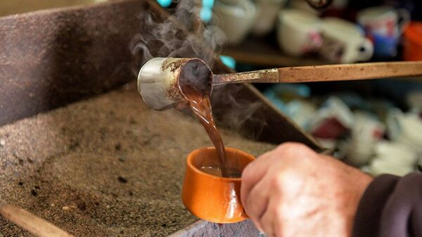 Кофе, сваренный в турке на песке, наливают в чашку - Sputnik Абхазия